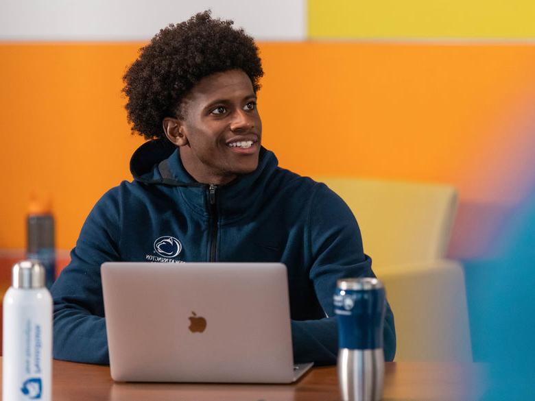 Student smiling working on a computer